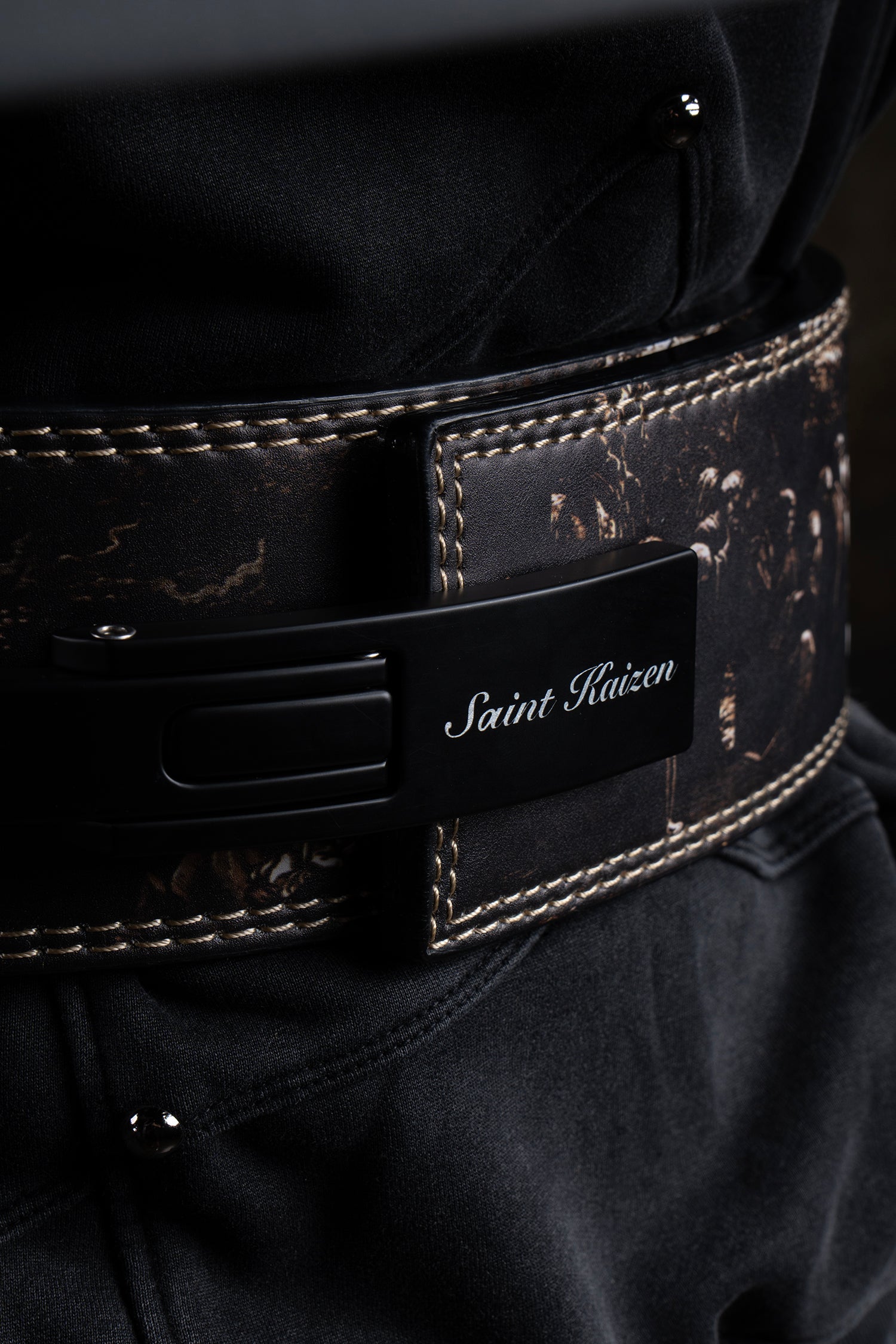 Close-up of the steel lever buckle on the Saint Kaizen Cross Camo Lever Belt. This 10mm Weightlifting belt is essential for Powerlifting and is favored by Christian athletes.