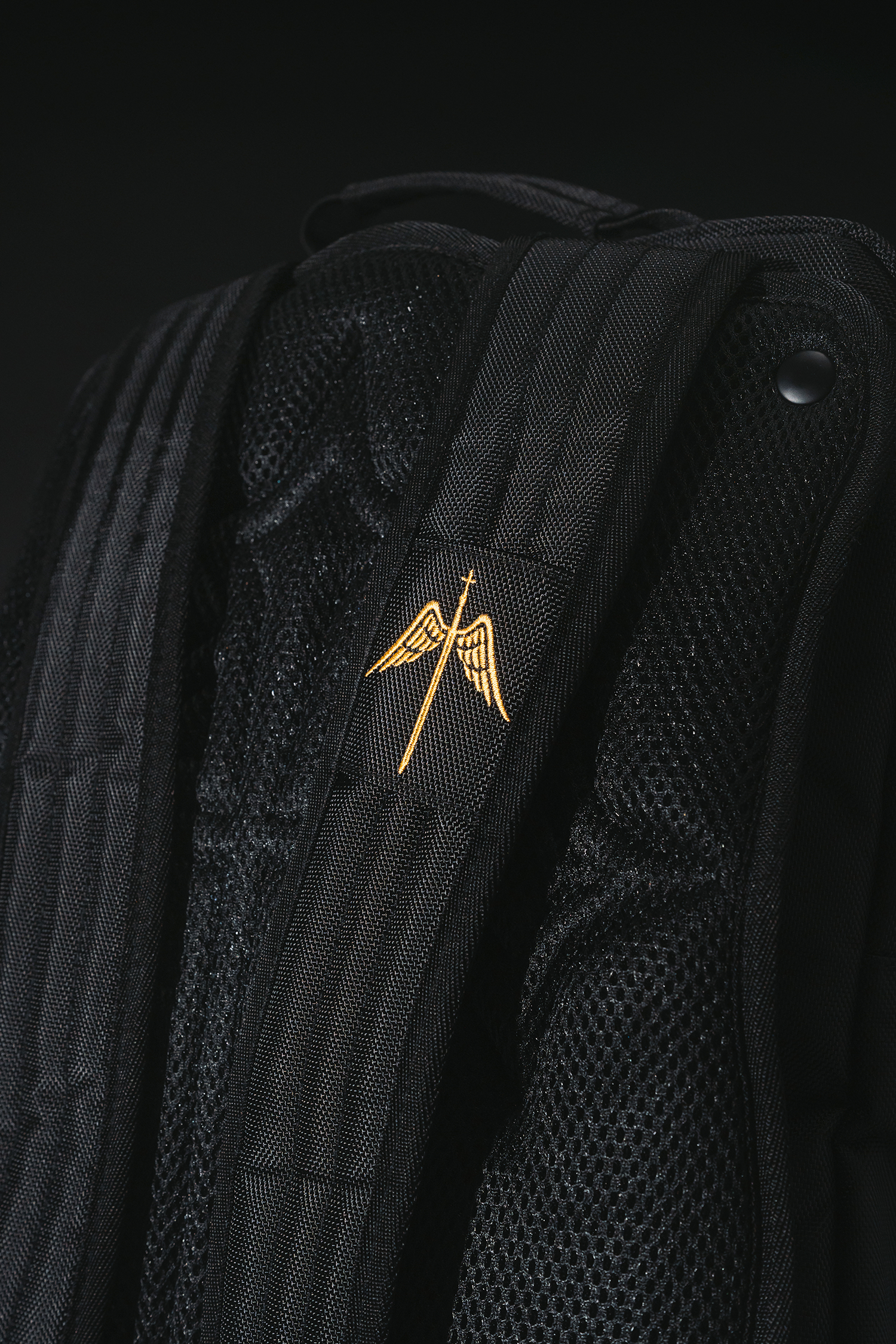 The back of the Fear Not Backpack showing the snap-secured Embossed Rear Plate and custom divine sword shoulder patch. A durable bag for Christians.