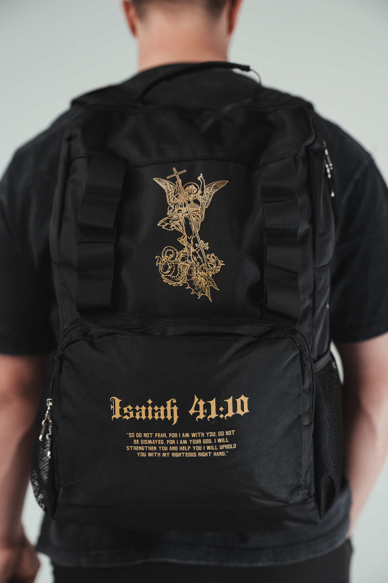 Saint Kaizen Fear Not Backpack for Christian athletes. Features Isaiah 41:10 text and gold silk-printed Archangel Michael artwork.