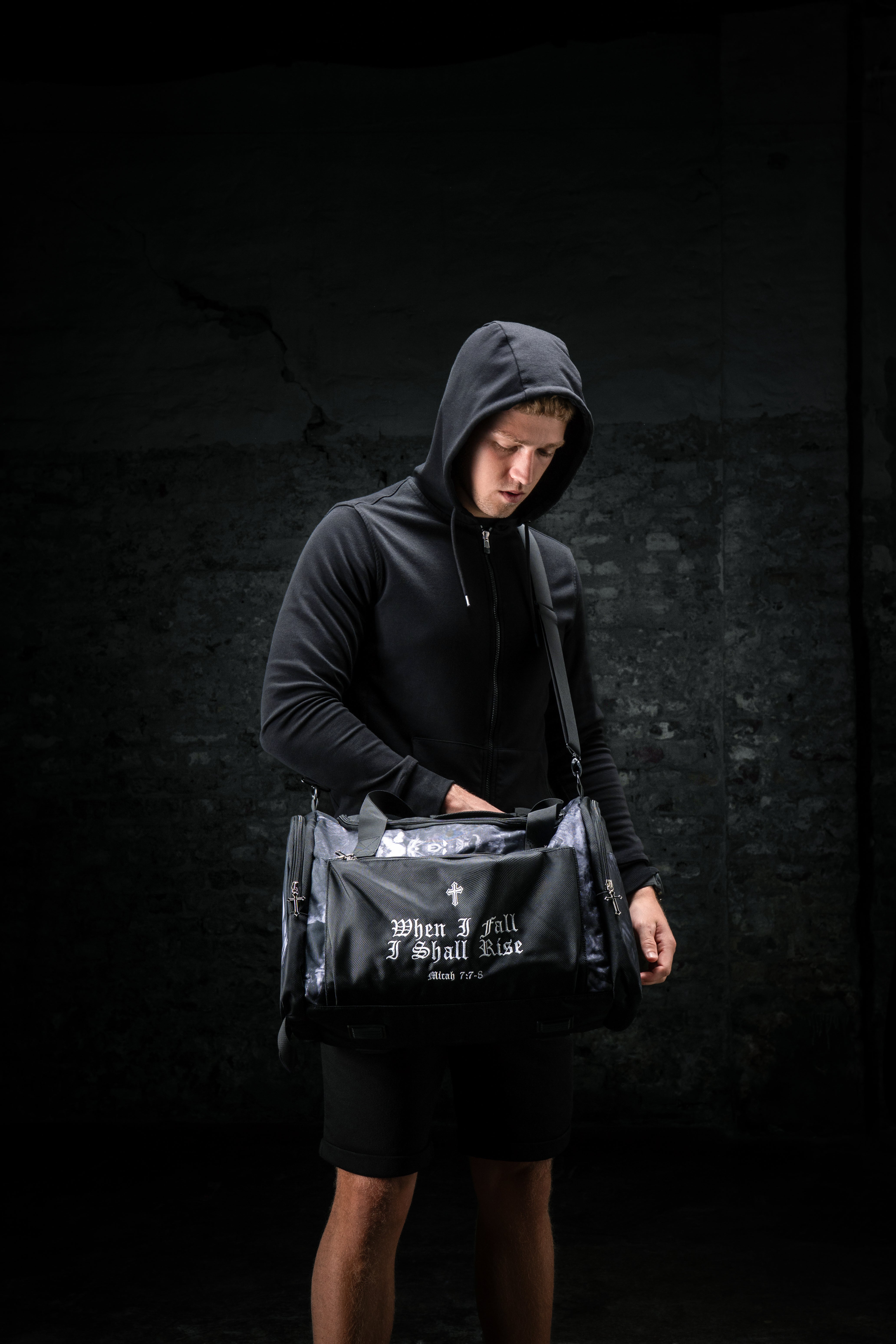 Saint Kaizen Christian gym duffle bag. Features the Light In The Darkness Duffle Bag verse, powerful spiritual artwork, and detailed embroidery for Christian athletes.