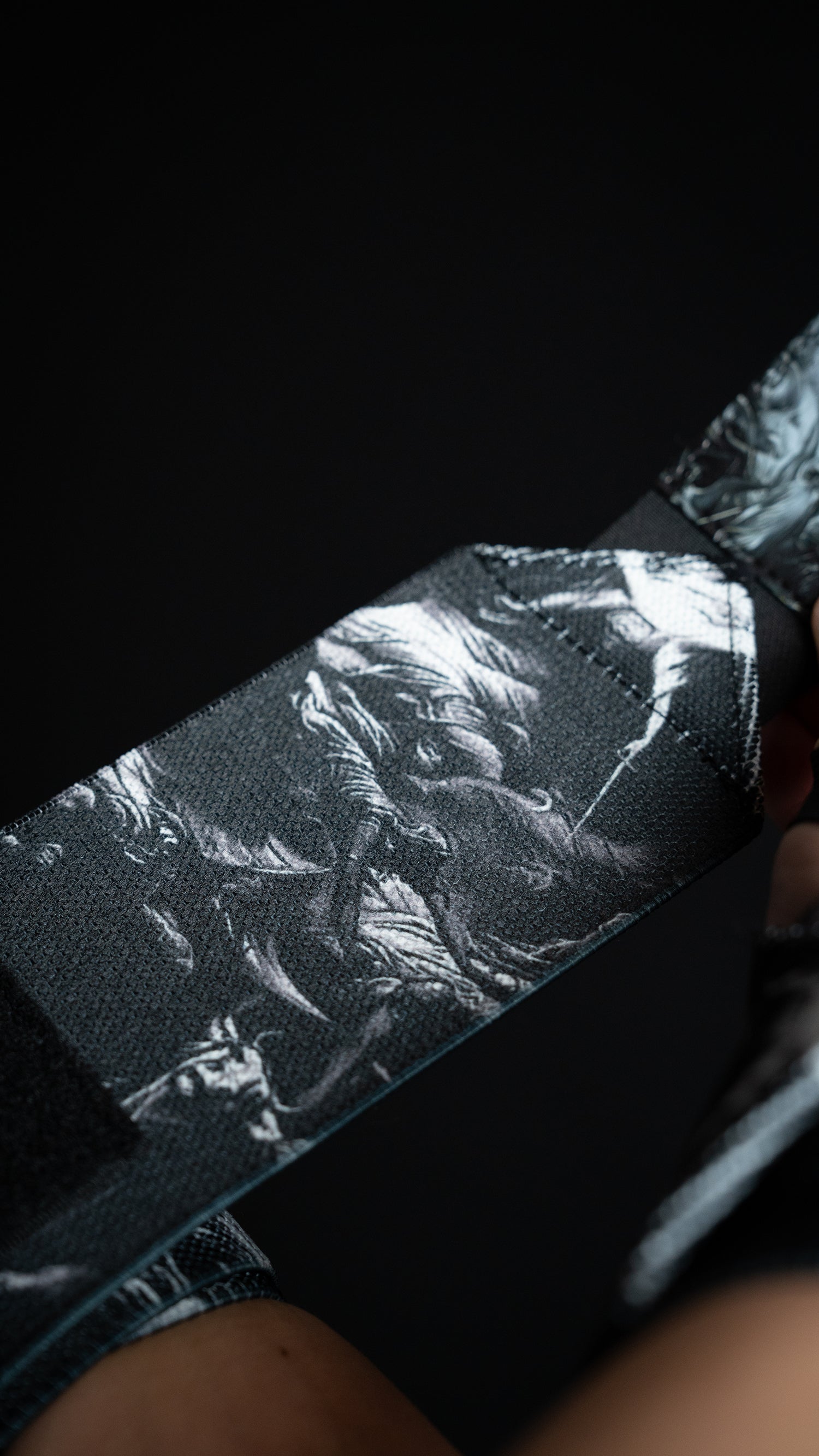 Saint Kaizen Light In The Darkness Wrist Wraps. Christian gym wear accessory featuring bold spiritual print and heavy-duty Velcro for stability.