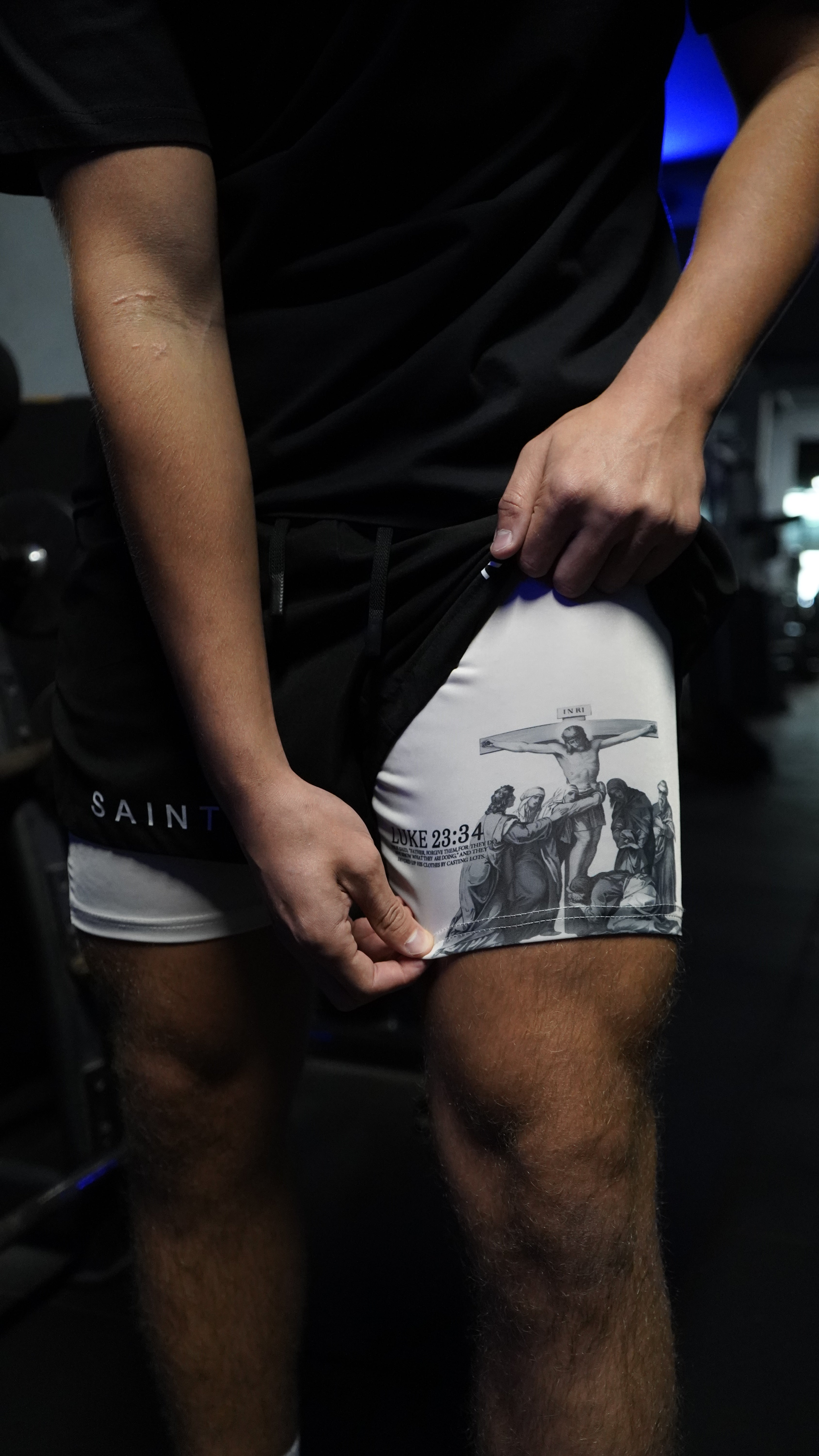Saint Kaizen Christian gym wear Luke 23:34 Performance Shorts - Black. Two-layer shorts built for optimal mobility, featuring secure pockets and premium fabric.